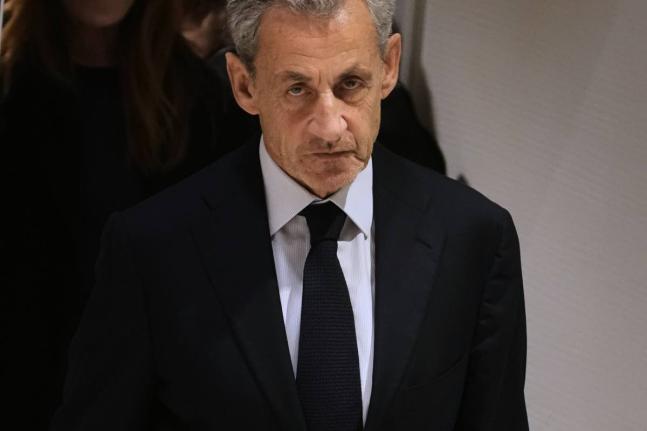 Former French President Nicolas Sarkozy leaves after a Paris court sentenced him to 5 years after finding him guilty of criminal conspiracy in an alleged scheme to finance his 2007 campaign with funds from Libya.