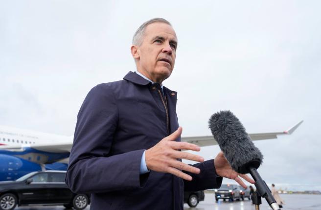 Canada Prime Minister Mark Carney speaks with members of the media before he boards a government plane in Ottawa on Friday.