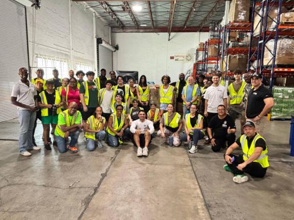 Marlon Hill, Lead Volunteer, Caribbean Strong, (left stooping), poses with the GEM team. 