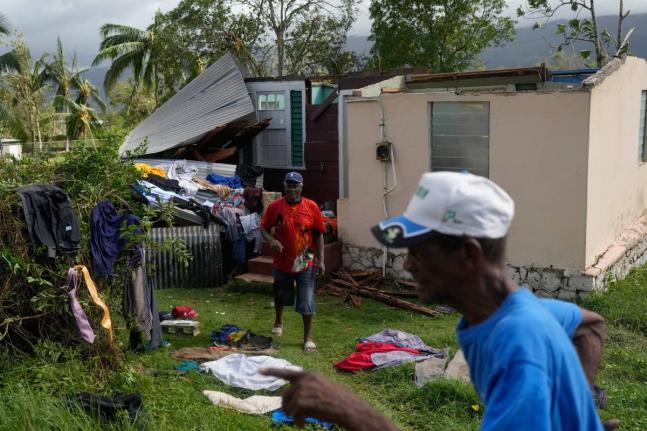 Residents dry belongings at a house damaged by Hurricane Melissa in Santa Cruz.