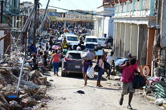 Persons travelling with supplies along Crane Road in Black River St Elizabeth, after Hurricane Melissa.