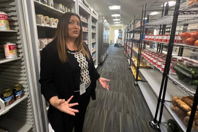 Danee Pye, a health communications and marketing specialist at California State University, Sacramento, gives a tour of a campus food pantry in the Basic Needs Resource Center.