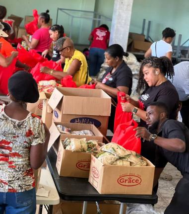 Volunteers from JMMB and the Council of Voluntary Services prepare care packages for distribution to communities impacted by Hurricane Melissa.