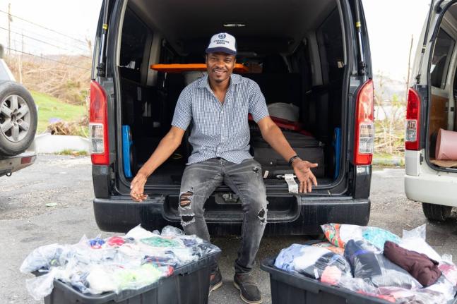 Beaming with gratitude, JPS’s Kenroy Williams displays donated clothing items that formed part of his community relief drive across Westmoreland, Hanover, and St James. Through partnerships with local businesses, individuals, and overseas supporters, Wil