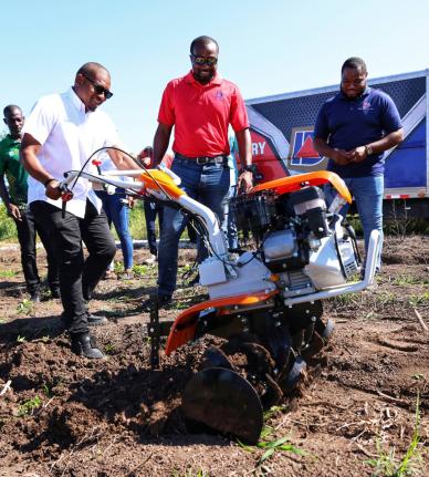 Minister of Agriculture, Fisheries and Mining, Floyd Green (left), uses one of the newly acquired walk behind tractors to plough land during a handover ceremony of walk behind tractors and earth augers on November 26, 2025 at the Amity Hall Agro Park in St