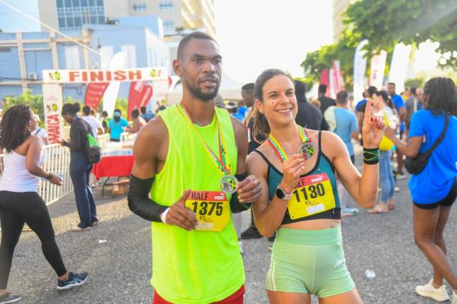 Garfield Gordon (left) and Cecile Heinrich pose with their medals after topping the men’s and women’s half marathon event, respectively, at the 2026 Reggae Marathon in downtown Kingston yesterday. 