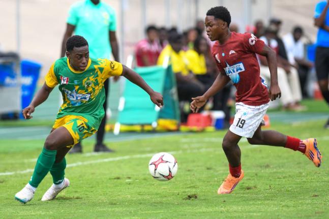 Excelsior High School’s Damarley Williams (left) rounds Eltham High School’s Kevin Clarke during the ISSA/WATA Manning Cup semi-finals at the National Stadium yesterday.