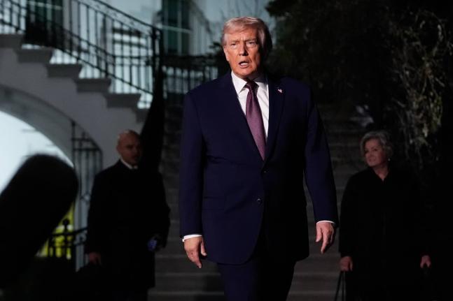 President Donald Trump walks to speak with reporters while departing the White House as chief of staff Susie Wiles, right, looks on, Friday, December 19, 2025, in Washington. (AP Photo/Julia Demaree Nikhinson)