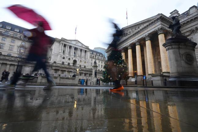 Pedestrians pass the Bank of England in London, as the Monetary Policy Committee (MPC) will publish their decision on interest rates, Thursday, December 18, 2025. 