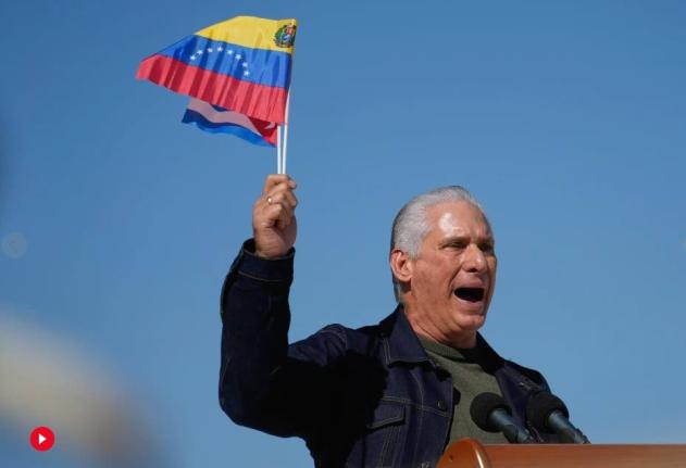 Cuban President Miguel Diaz-Canel waves Venezuelan and Cuban national flags during a rally in Havana, Saturday, January 3, 2026, in solidarity after the US captured President Nicolas Maduro and flew him out of Venezuela. (AP Photo/Ramon Espinosa)