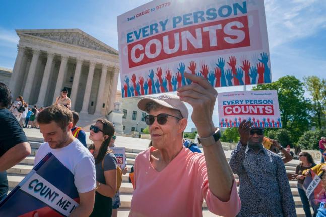 Immigration activists rally outside the Supreme Court as the justices hear arguments over the Trump administration’s plan to ask about citizenship on the 2020 census, in Washington DC.