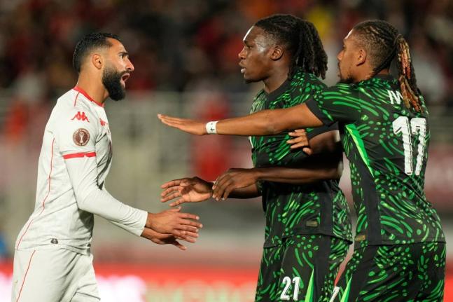 Tunisia’s Ali Abdi (left) argues with Nigeria’s Calvin Bassey and Alex Iwobi (right) during the Africa Cup of Nations group C football match in Fez, Morocco, on Saturday, December 27, 2025.