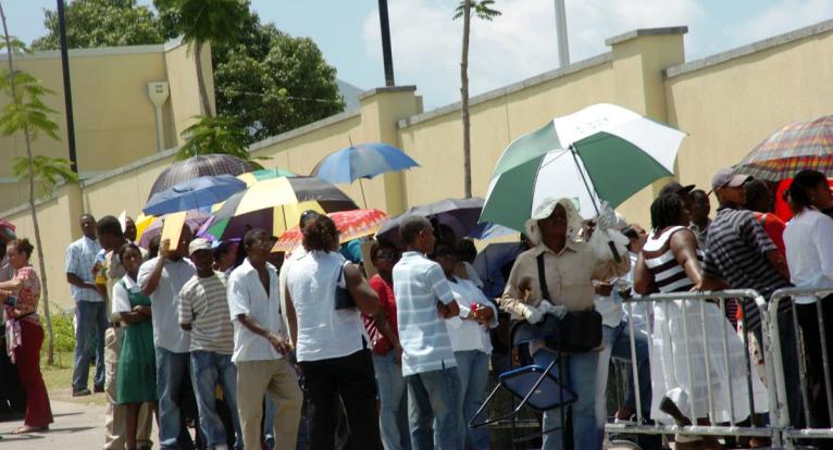 In this file photo visa applicants are seen waiting outside the US Embassy in Kingston.