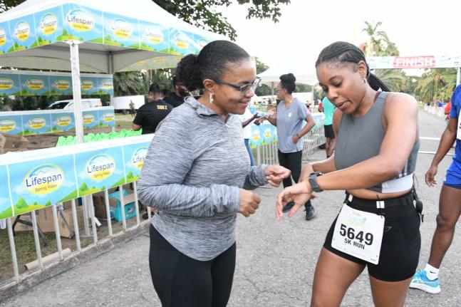 Claudine Allen, general manager of the JN Foundation (left), has a conversation with Dandie Williams, from the Pacers Running Club, who was the first woman to complete the JN Group Race for Hope 5K at Hope Gardens on Sunday.