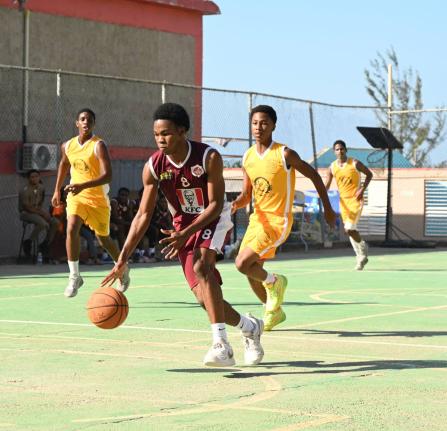 Herbert Morrison Technical High School’s Ryan Jurdine (front) dribbles away from Garvey Maceo High School’s Nicade Bachan (right) during their ISSA Schoolboys Rural Basketball quarterfinal match at the Herbert Morrison court yesterday.