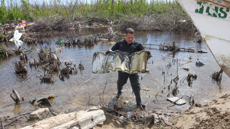 Matthew Samuda, minister of water, environment and climate change removes debris from a mangrove ecosystem in Parottee, St. Elizabeth, during clean-up activity marking World Wetlands Day on February 2. 