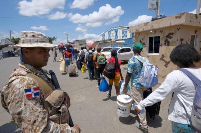 Dominican Republic security forces stand guard on a border bridge between Dajabón, Dominican Republic, and Haiti, Thursday, September 14, 2023. (AP Photo/Ricardo Hernández)