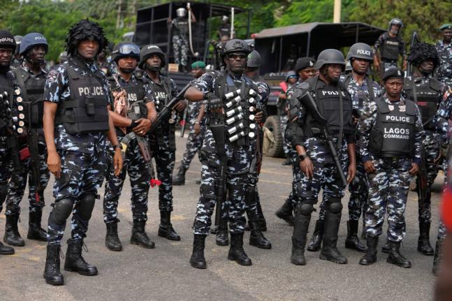  Nigeria police officers stand guard during a candle light procession in honour of all protesters killed nationwide at the recently economic hardship protest, in Lagos, Nigeria, Friday, August 9, 2024. (AP Photo/Sunday Alamba, file)