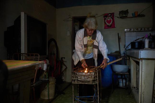Minorkys Hoyos Ruiz lights coals to cook dinner during a scheduled blackout to ration energy in Santa Cruz del Norte, home to one of Cuba’s largest thermoelectric plants, late afternoon Tuesday, Feb. 3, 2026. 