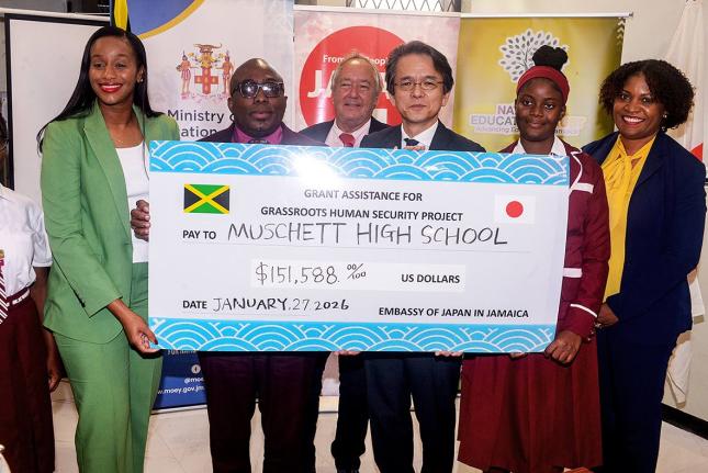 Minister of State in the Ministry of Education, Skills, Youth and Information, Rhoda Moy Crawford (left), joins Principal of Muschette High School in Trelawny, Leighton Johnson (second left), as he receives a cheque valued US$151,588 from Japan’s Ambassa