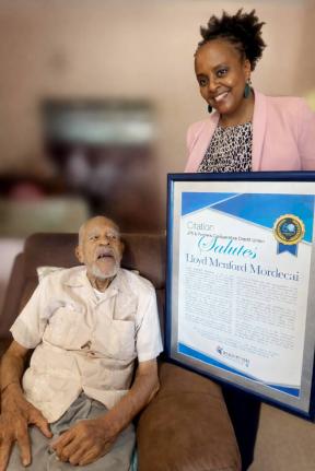 Camille Archibald, business development manager of JPS & Partners Co-op Credit Union, presents a citation to Lloyd Menford Mordecai, whose early efforts helped lay the foundation for the strong credit union we know today.