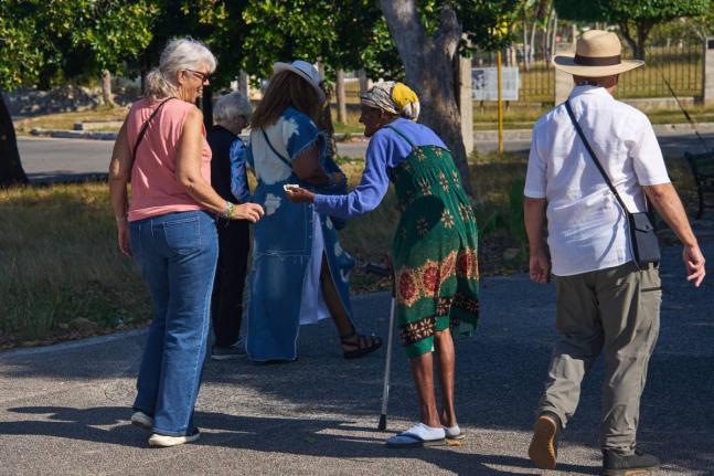 An elderly woman begs for alms from tourists in Havana, Cuba.