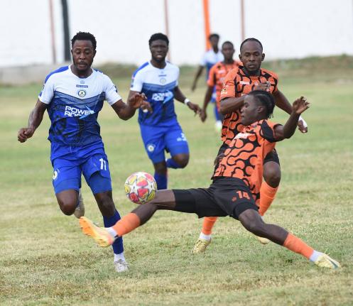 Mount Pleasant’s Football Academy’s Jashaun Angli (left) tries to evade the sliding challenge of Tivoli Garden’s Denville Watson during their rescheduled Jamaica Premier League game at the Edward Seaga Sports Complex yesterday. Anglin scored in the 1