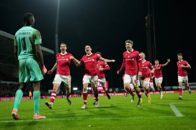 Wrexham’s goalkeeper Arthur Okonkwo (left) celebrates with teammates after a penalty shootout at the end of the English FA Cup third round  match between Wrexham and Nottingham Forest in Wrexham, Wales, on January 9, 2026. 