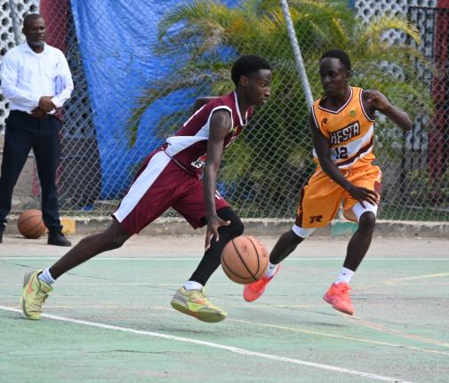 Herbert Morrison Technical High’s Michael Johnson (left) dribbles past  Manchester High’s Waine Green Jr during game one of their ISSA Rural Schoolboys Under-16 Basketball finals at Herbert Morrison’s court on Monday, March 2, 2026.