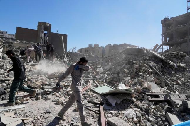 A group of men inspect the ruins of a police station struck Monday amid the U.S.–Israeli military campaign in Tehran, Iran.