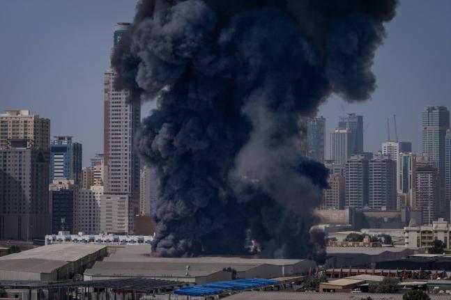 A black plume of smoke rises from a warehouse in the industrial area of Sharjah City following reports of Iranian strikes in Dubai, United Arab Emirates.