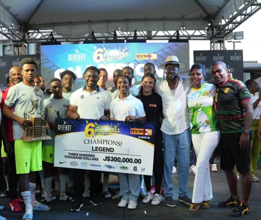 Former St Vincent and the Greandines national player Renson Haynes (right) and Shelly-Ann Fraser-Pryce (centre) help Legend celebrate winning the 10th Pocket Rocket Foundation Six-A-Side Football Competition at the Wray and Nephew football field on Sunday.