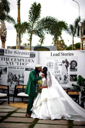 The couple share an enchanting kiss in front of an extravagant newspaper announcement marking their wedding.