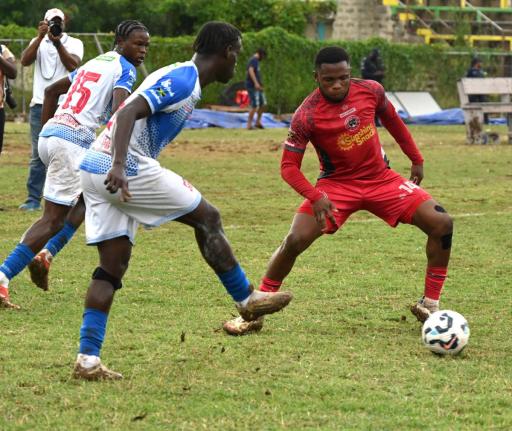 Montego Bay United’s Okeemo Jones (right) tries to intercept a pass from Dunbeholden FC’s Odae Samuels during their Jamaica Premier League football game at Jarrett Park in Montego Bay yesterday.