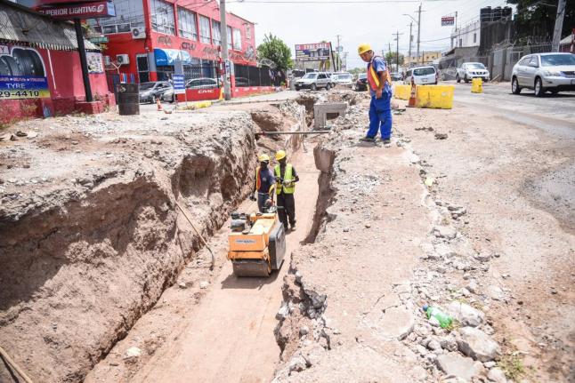 Workmen operate a road roller along a section of roadway under the Hagley Park Road Improvement Project in St Andrew in 2018.