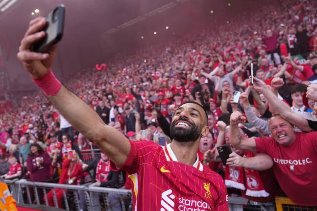 Liverpool’s Mohamed Salah celebrates by taking a selfie after winning the English Premier League football match against Tottenham Hotspur and clinching the Premier League title at Anfield in Liverpool, England on April 27, 2025.