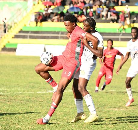 Montego Bay United’s Jahmari Clarke shields  the ball from Cavalier’s Jahdiel Russell during their Jamaica Premier League match at Jarrett Park in Montego Bay yesterday. Montego Bay won 3-1.