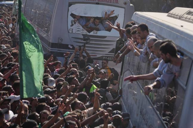 People gather to greet freed Palestinian prisoners arriving on buses in the Gaza Strip after their release from Israeli jails under a ceasefire agreement between Hamas and Israel, outside Nasser Hospital in Khan Younis, southern Gaza Strip on October 13, 2