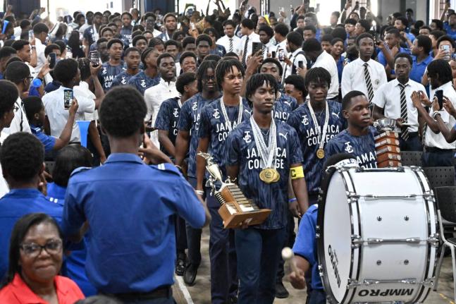 Jamaica College athletes march into the auditorium for Monday’s celebrations following their victory in the ISSA/GraceKennedy Boys’ Championships on the weekend.