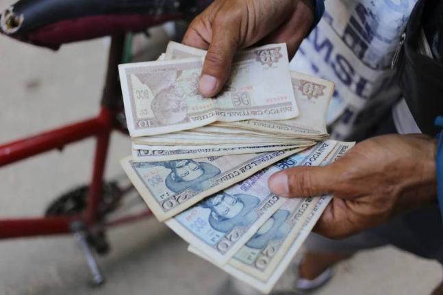 An ice cream street vendor shows his Cuban pesos in Havana, Cuba, April 20, 2024. 