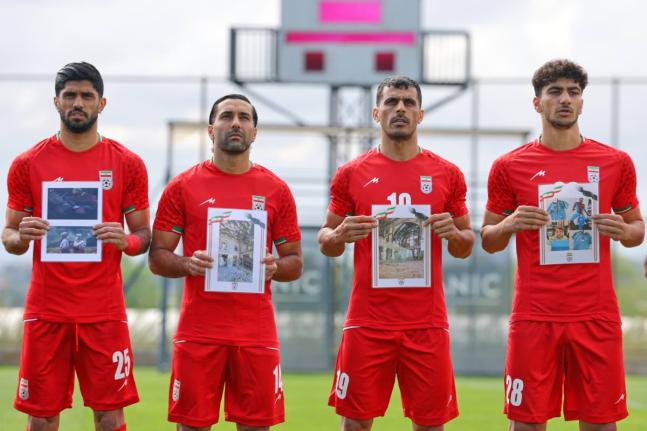 Iran’s players sing the national anthem, holding pictures of children allegedly killed in US and Israel strikes in Iran, before a friendly football match against Costa Rica, in Antalya, southern Turkey, yesterday.
