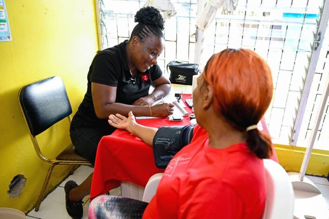 Medical assistant at the Heart Foundation of Jamaica (HFJ),  Donna-Marie Dacres, records a patient’s blood pressure results during the St Catherine High School’s health fair held at the institution recently. 