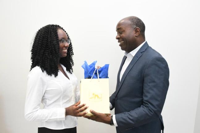 Jadyn Sinclair (left), winner of the 2025 Union of Jamaican Alumni Associations Essay Competition, accepts a gift from Hugh Miller, acting general manager of the JN Financial Group, at the JN Group Corporate Offices recently. The occasion was a courtesy ca