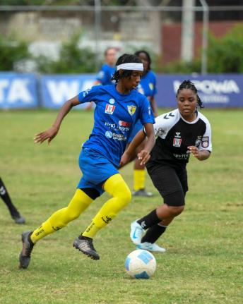 Antoine Lodge/Photographer 
Real Mona’s Olivia Ashbourne (left) tries to drive past Cavalier SC’s Torri-Ann Harris during their Jamaica Women’s Premier League fixture at the Alpha Institute yesterday.