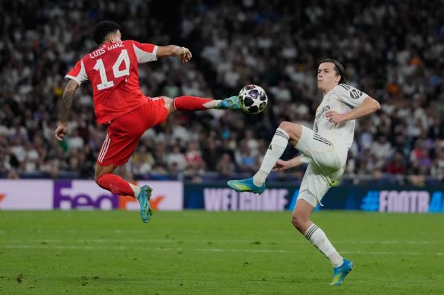 Real Madrid’s Alvaro Carreras (right) and Bayern Munich’s Luis Diaz challenge for the ball during the Champions League quarter-final first-leg football match in Madrid, Spain, yesterday.