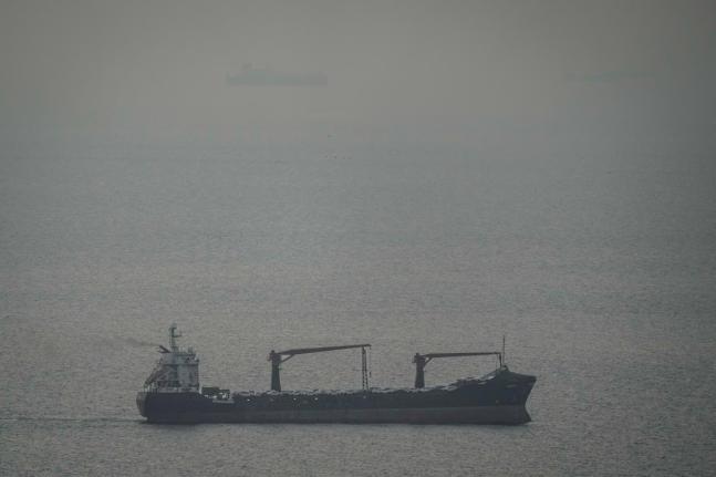 A cargo ship carrying vehicles sails through the Arabian Gulf toward the Strait of Hormuz in the United Arab Emirates.