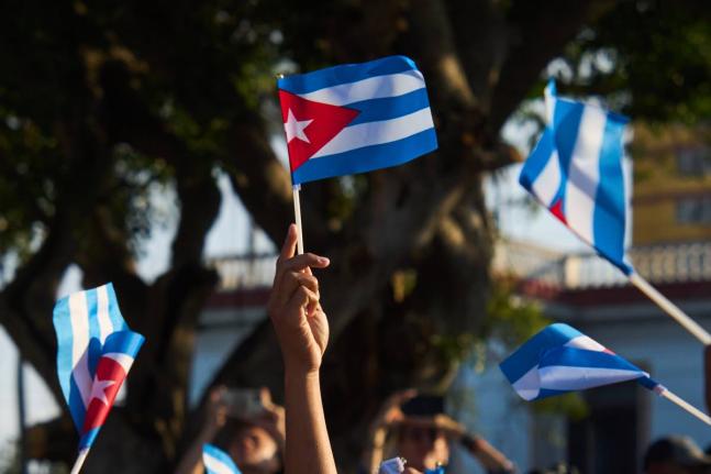Women wave Cuban flags during a rally calling for the end of the U.S. blockade against the island nation in Havana, Cuba on April 7, 2026. (AP Photo/Ramon Espinosa)
