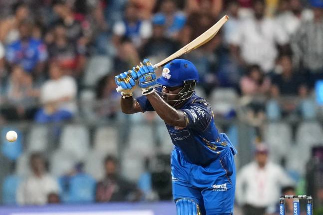 Mumbai Indians’ West Indian batsman Shefane Rutherford hits a boundary during the Indian Premier League cricket match between Mumbai Indians and Royal Challengers Bengaluru, in Mumbai, India, yesterday. Rutherford hit nine sixes in an unbeaten 31-ball 71