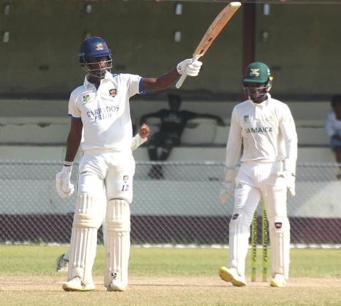 Barbados Pride batsman Kevin Wickham raises his bat after getting to 150 against the Jamaica Scorpions at Chedwin Park yesterday. Wicketkeeper Romaine Morris looks on.