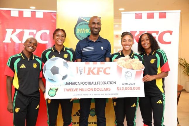 
Reggae Girlz Deneisha Blackwood (left), Allyson Swaby (second left), Kameron Simmonds(second right), and Atlanta Primus (right) flank KFC Jamaica marketing manager, Andrei Roper, who displays a cheque for $12 million, which represents the first instalment